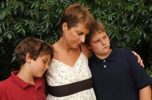 Mother (could be single parent) and two sons expressing sadness and loss