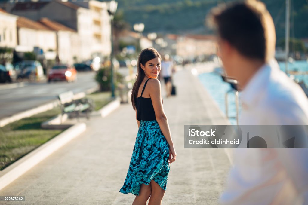 Jeune femme séduisante, flirter avec un homme dans la rue. Sexy femme souriante regardant en arrière sur un bel homme. Attraction femelle. L’amour à première vue. Réunion ex petit ami - Photo de Précédent libre de droits