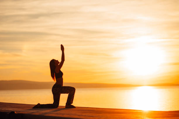 Carefree woman meditating in nature.Finding inner peace.Yoga practice.Spiritual healing lifestyle.Enjoying peace,anti-stress therapy,mindfulness meditation.Positive energy.Crescent lunge poseCarefree woman meditating in nature.Finding inner peace.Yoga practice.Spiritual healing lifestyle.Enjoying peace,anti-stress therapy,mindfulness meditation.Positive energy.Crescent lunge pose carefree mujer meditando en la naturaleza. encontrar la paz interior. práctica del yoga. estilo de vida de curación espiritual. disfrutar de paz, terapia anti-stress, meditación de atención plena. energía positiva. estocada media luna plantean