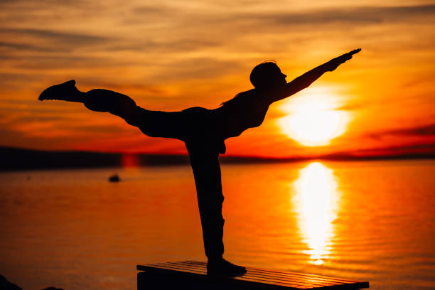 Carefree woman meditating in nature.Finding inner peace.Yoga practicing.Spiritual healing lifestyle.Enjoying peace,anti-stress therapy,mindfulness meditation.Positive energy.Dekasana,airplane pose carefree mujer meditando en la naturaleza. encontrar la paz interior. práctica de yoga. estilo de vida de curación espiritual. disfrutar de paz, terapia anti-stress, meditación de atención plena. energía positiva. dekasana, pose de avión