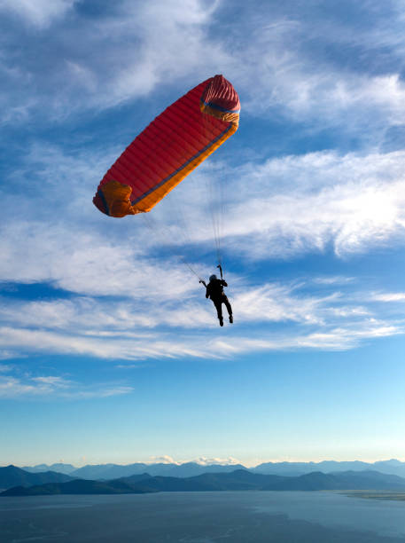 istock paraglider is flying in the blue sky 922676674