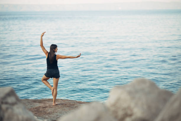 Carefree woman meditating in nature.Finding inner peace.Yoga practice.Spiritual healing lifestyle.Enjoying peace,anti-stress therapy,mindfulness meditation.Positive energy.Tree pose,VrksasanaCarefree woman meditating in nature.Finding inner peace.Yoga practice.Spiritual healing lifestyle.Enjoying peace,anti-stress therapy,mindfulness meditation.Positive energy.Tree pose,Vrksasana carefree mujer meditando en la naturaleza. encontrar la paz interior. práctica del yoga. estilo de vida de curación espiritual. disfrutar de paz, terapia anti-stress, meditación de atención plena. energía positiva. postura del árbol, vrksasana