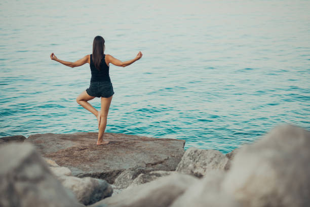 Carefree woman meditating in nature.Finding inner peace.Yoga practice.Spiritual healing lifestyle.Enjoying peace,anti-stress therapy,mindfulness meditation.Positive energy.Tree pose,Vrksasana carefree mujer meditando en la naturaleza. encontrar la paz interior. práctica del yoga. estilo de vida de curación espiritual. disfrutar de paz, terapia anti-stress, meditación de atención plena. energía positiva. postura del árbol, vrksasana