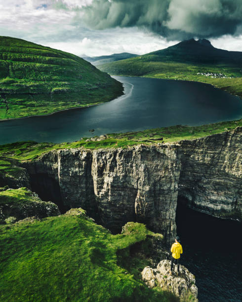 Panoramic view of Kallur Lighthouse at Kalsoy Island on a cloudy day with dramatic skies on Faroe Islands, Denmark.