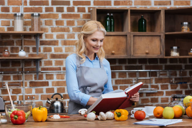 istock woman reading recipe book in kitchen 922680774