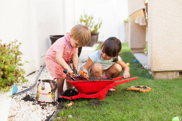 Toddler Kids Playing Outside With Mud in Summer