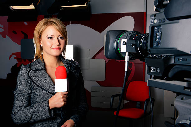 Real tv news reporter in front of the video camera stock photo