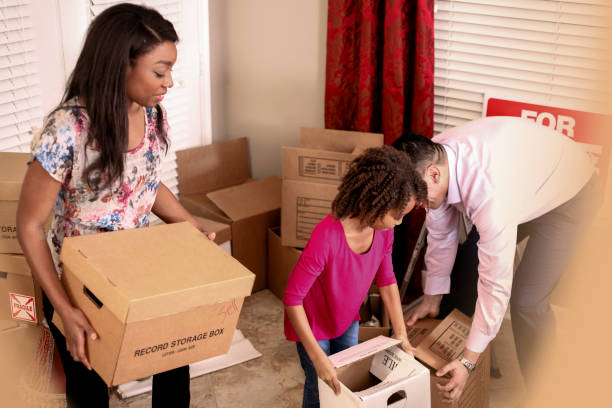 istock Multi-ethnic family packs, unpacks moving boxes in new home. 922682374