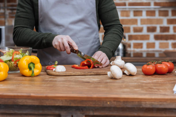istock cropped image of man cutting bell pepper in kitchen 922682594