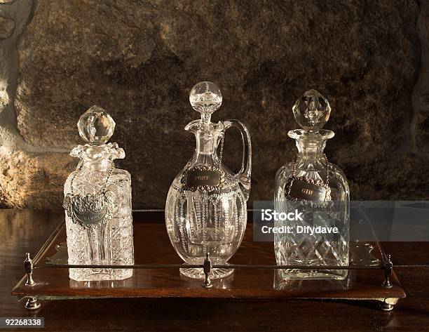 Foto de Várias Garrafas De Cristal Antigos Na Bandeja De Madeira e mais fotos de stock de Cristais