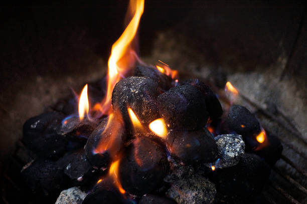 charcoal burning on a grill stock photo