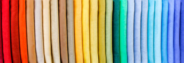 Rainbow clothes background. Pile of bright folded clothes.