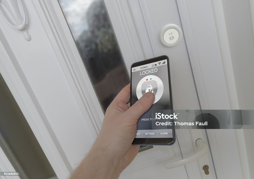 Using a smartphone to open an electronic lock on a front door Using a smartphone to open a smart lock on a front door Locking Stock Photo