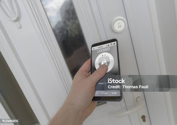 Using A Smartphone To Open An Electronic Lock On A Front Door Stock Photo - Download Image Now