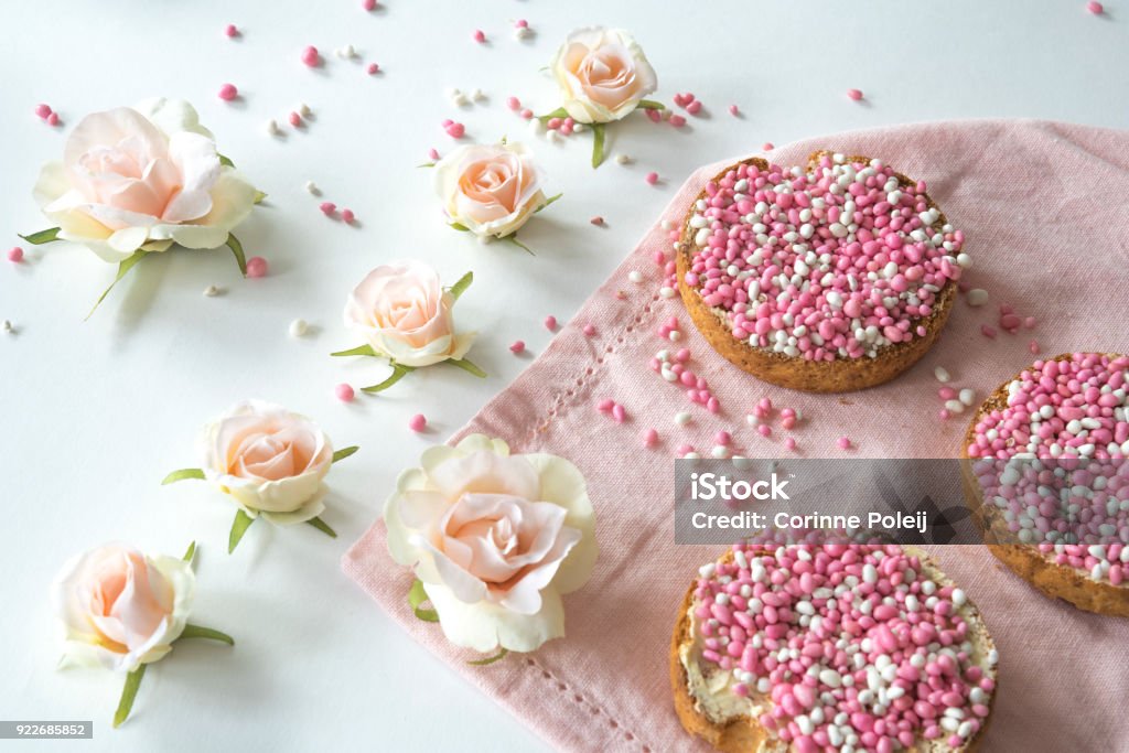 traditional Dutch food pink muisjes, aniseed on rusk, roses, for celebration birth of a daughter typical Dutch treat rusk with pink muisjes, aniseed for celebrating a baby girl, daughter is born Anise Stock Photo