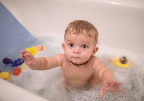 istock Curious Baby boy is looking over the camera while taking the bath with foam 922685922