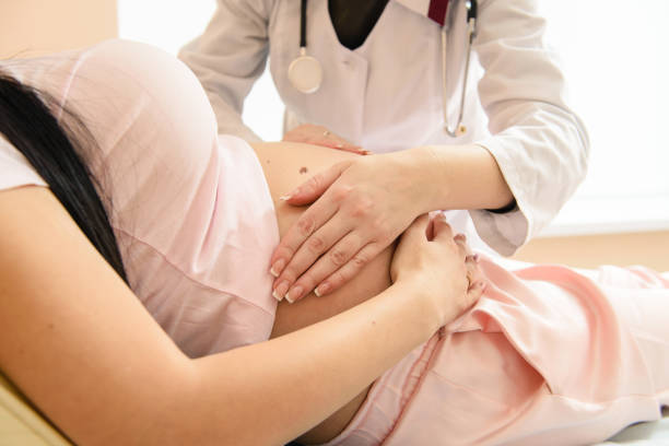 Doctor touch pregnant tummy with hands Close-up hand check of pregnancy in hospital pregnancy and childbirth stock pictures, royalty-free photos & images