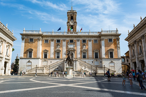 ROME, ITALY - AUGUST 31, 2017: Tourists at Piazza del Campidoglio on top of Capitoline Hill and Palazzo Senatorio, Rome, Italy.