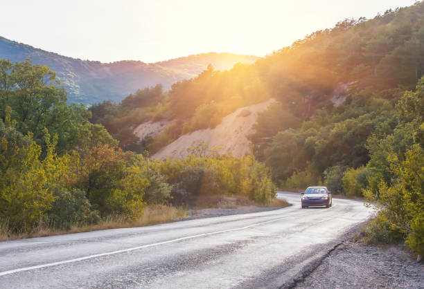 istock landscape with mountains, road and car 922695348