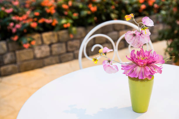A colorful metal  folding table and chair set on a brick patio