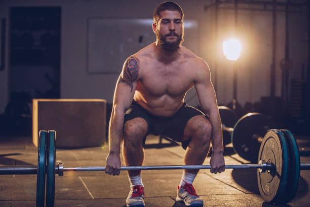 istock Sporty man lifting weights in the gym 922699218