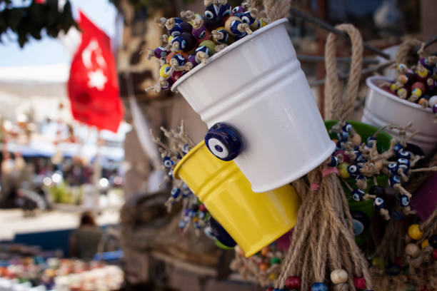 deko-objekte, die mit bösen augen. türkische flagge wellen im hintergrund in cunda (alibey) insel. - nazar boncugu stock-fotos und bilder