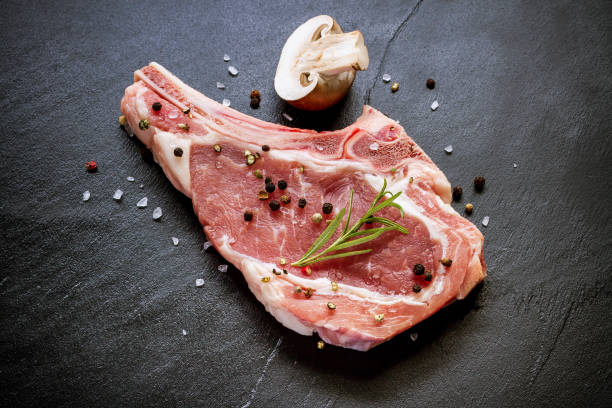 Raw veal cutlet at black slate plate