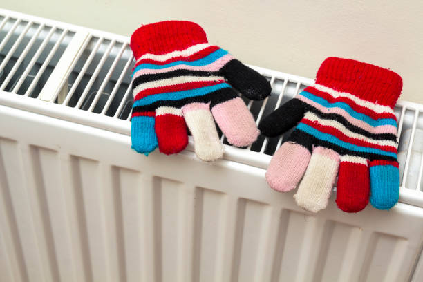 istock Children's warm hand knitted striped woolen gloves drying on hea 922700758