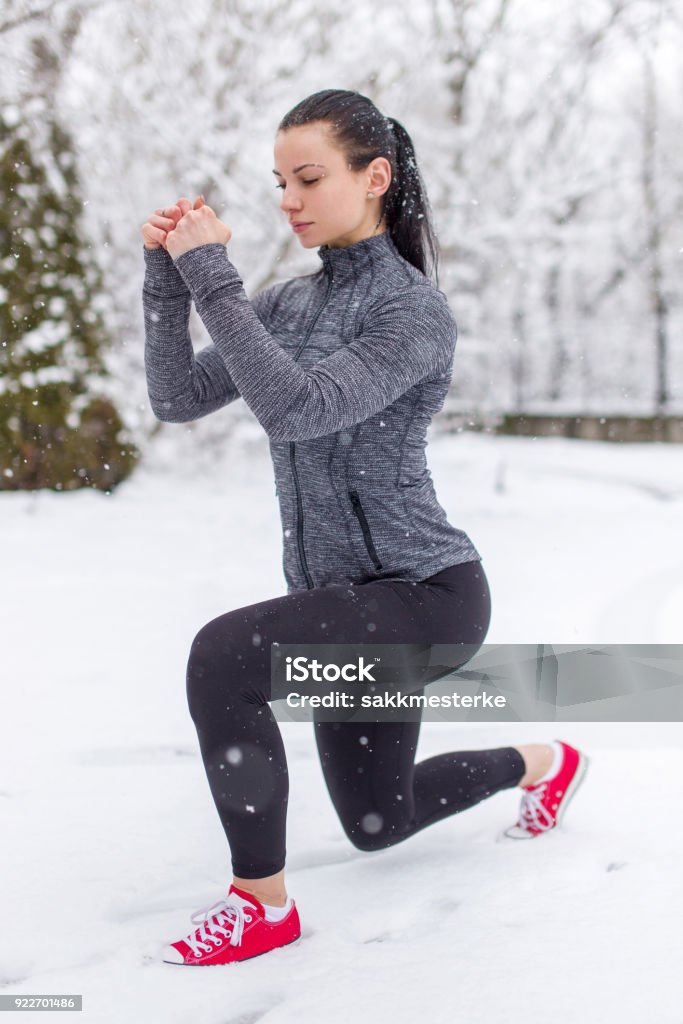 Junge Frau, die Longe Übung mit der Kettlebell im Schnee - Lizenzfrei Aktiver Lebensstil Stock-Foto