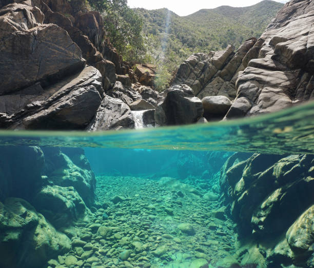 istock Over and underwater river rocks with clear water 922701506