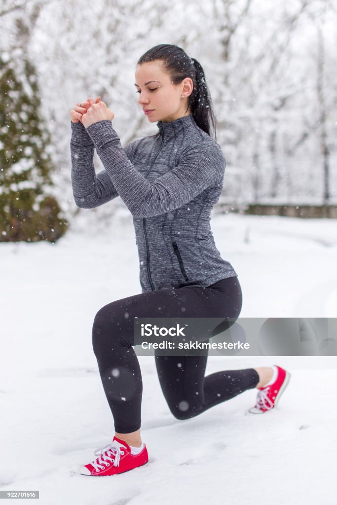 Young passen kaukasischen Frau Ausfallschritt trainieren im Schnee im Winter Augen geschlossen - Lizenzfrei Aktiver Lebensstil Stock-Foto