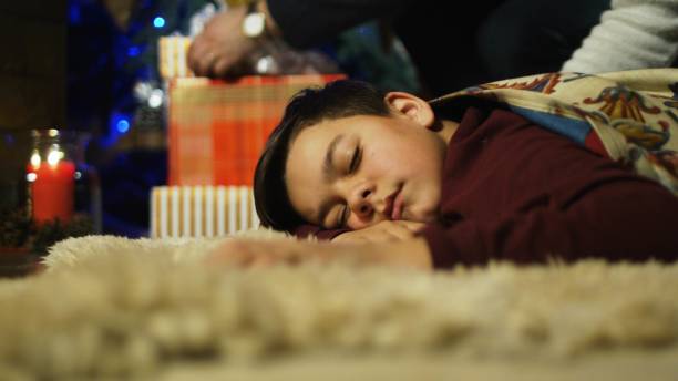 istock Kid sleeping near fireplace in Christmas night 922703018