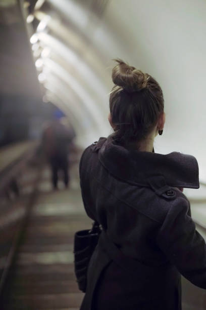 istock Young woman on a moving staircase  in a subway 922703100