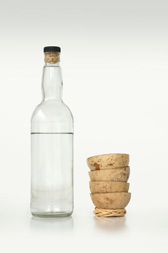 Three vintage glass bottles  including a soda pop bottle, a medicine bottle and a perfume bottle with reflections on a black background.