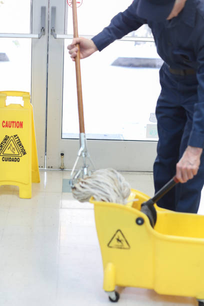 istock Unrecognizable man mopping floor in office building. 922709190