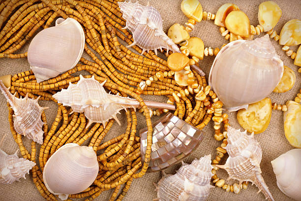 ámbar y joyas sandalwood con conchas de mar sobre fondo de lona - multichain necklace fotografías e imágenes de stock