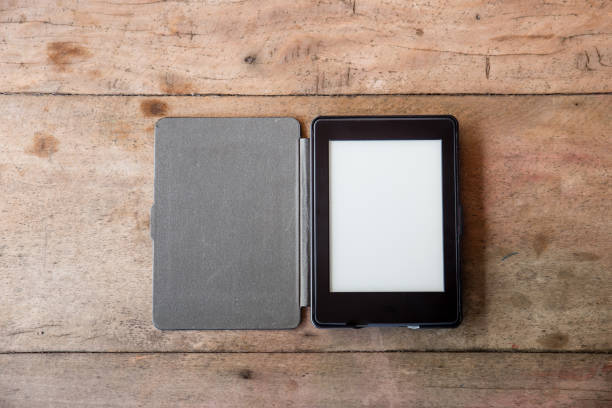 İstanbul, Turkey - July 7, 2014: Hands holding 4th generation Amazon.com e-book reading device Kindle on a white background.