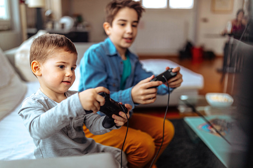 Photo children playing with video games at home