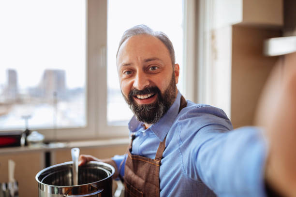 Selfie in the kitchen Photo of mature man taking selfie in the kitchen thumb photos stock pictures, royalty-free photos & images