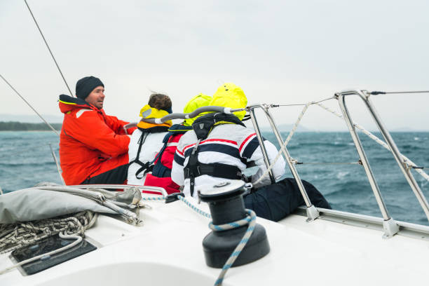 istock Group of People Sitting on Sailboat Edge 922714034