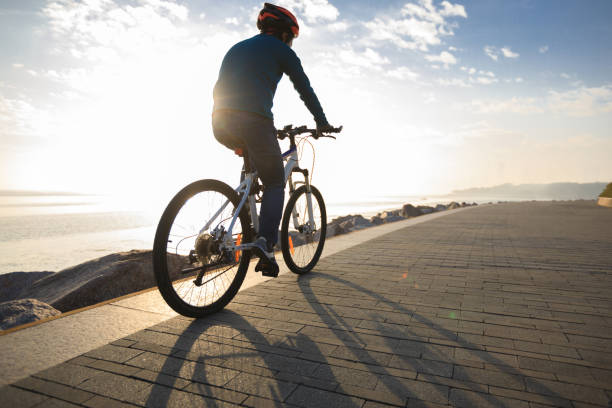 istock cyclist riding bike in the sunrise coast path 922714892