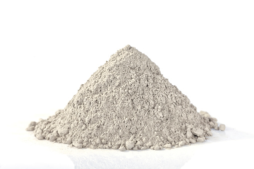 Heap of cement powder intended for industry isolated on white.
