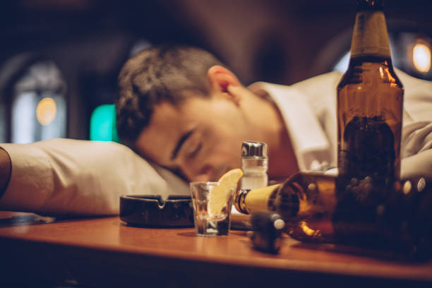 young drunk man sleeping on bar counter - drunk imagens e fotografias de stock