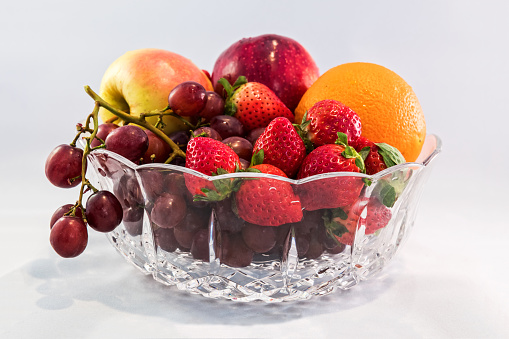 A fresh bowl of fruit with neutral white background.