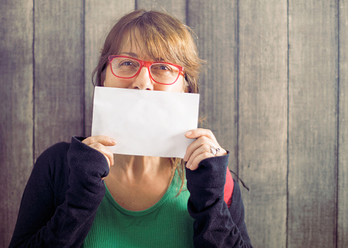 Mature mid age woman holding blank board