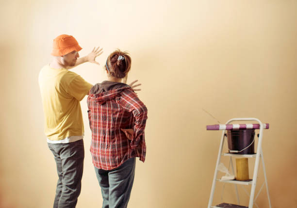 istock Diy friends applying wallpaper on wall in new home 922717046