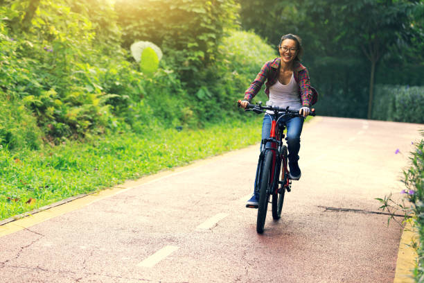 istock happy young woman cyclist cycling on forest trail 922717202