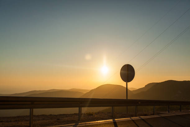 istock view from the road to the setting sun behind the hills. 922717348