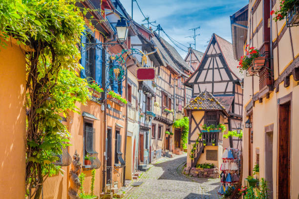 Historic town of Eguisheim, Alsace, France Charming street scene with colorful houses in the historic town of Eguisheim on a beautiful sunny day with blue sky and clouds in summer, Alsace, France ardennes department france stock pictures, royalty-free photos & images