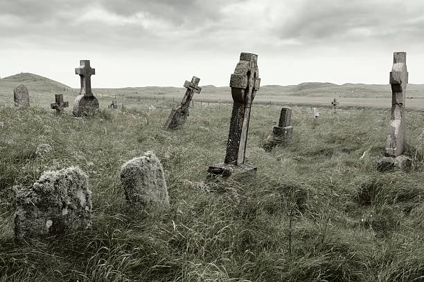 мрачный захоронении - old cross shape stone weathered стоковые фото и изображения